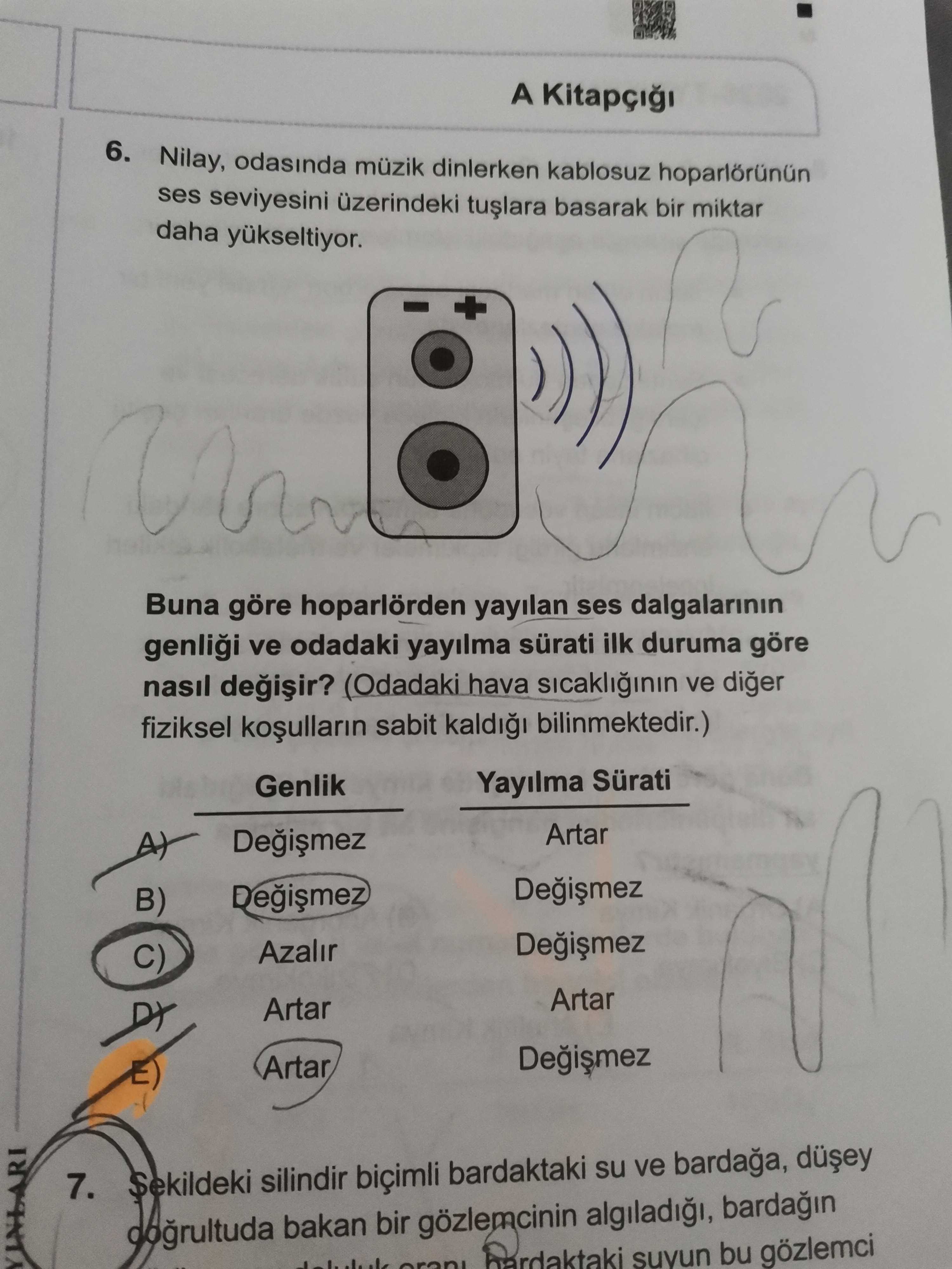 Nilay, odasında müzik dinlerken kablosuz hoparlörünün ses seviyesini üzerindeki tuşlara basarak bir