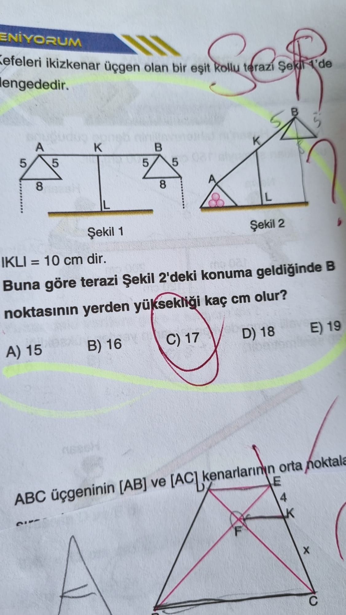 Kefeleri ikizkenar üçgen olan bir eşit kollu terazi Şekil 1'de dengededir. |KL| = 10 cm dir. Buna