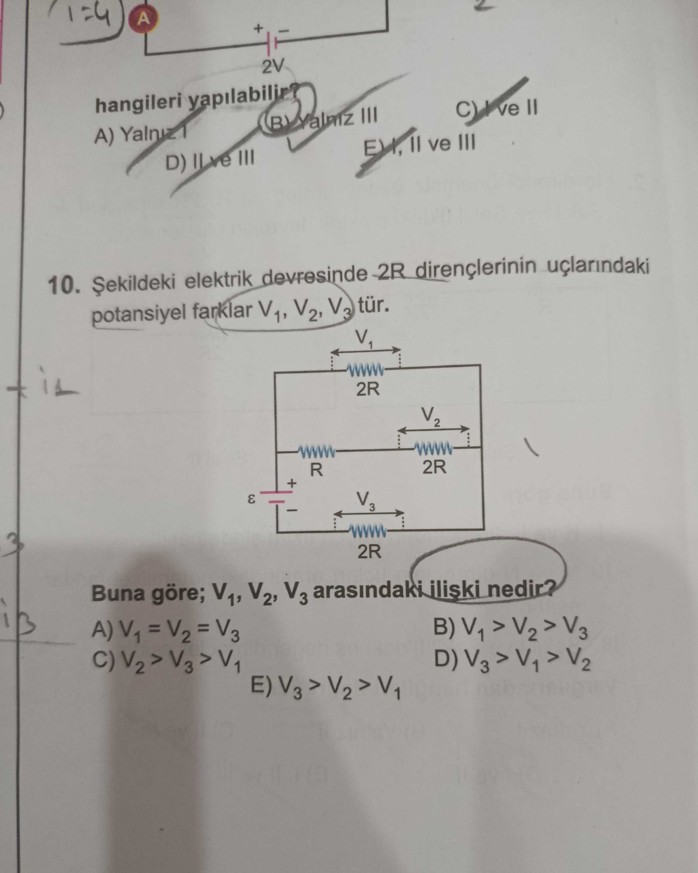 Şekildeki elektrik devresinde 2R dirençlerinin uçlarındaki potansiyel farklar V₁, V₂, V₃ tür. Buna