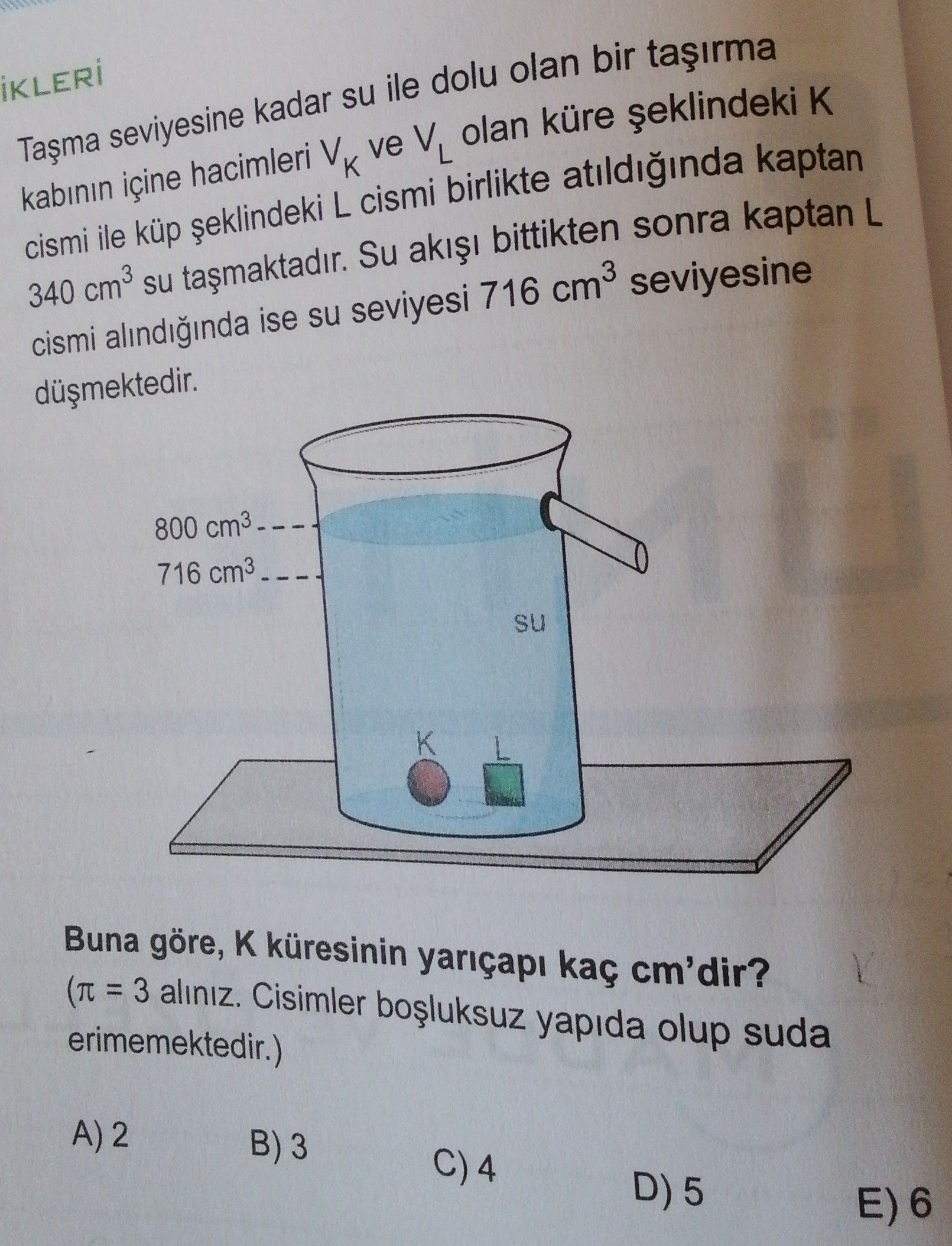Taşma seviyesine kadar su ile dolu olan bir taşırma kabının içine hacimleri V_K ve V_L olan küre