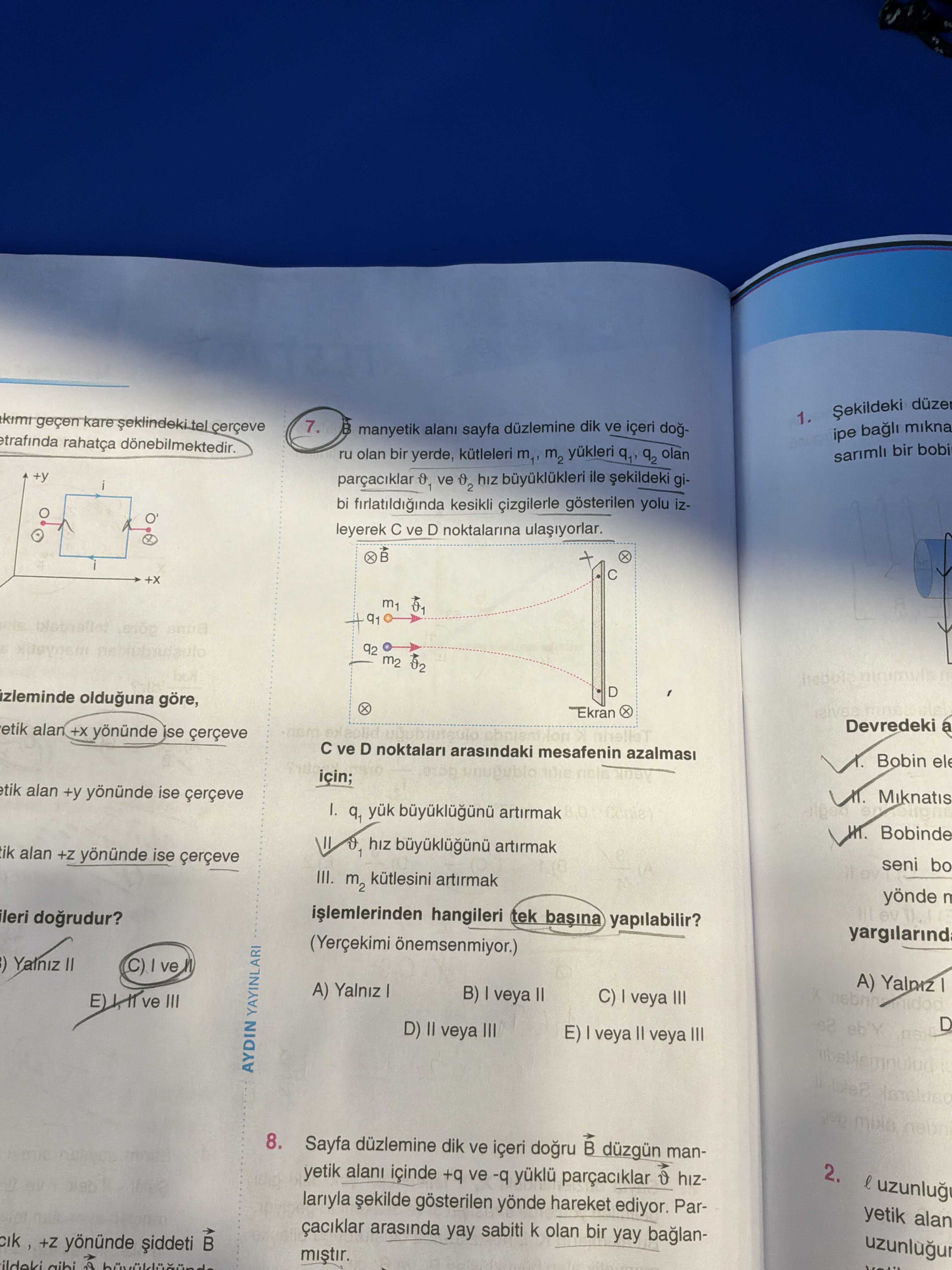 B manyetik alanı sayfa düzlemine dik ve içeri doğru olan bir yerde, kütleleri m₁, m₂ yükleri q₁, q₂