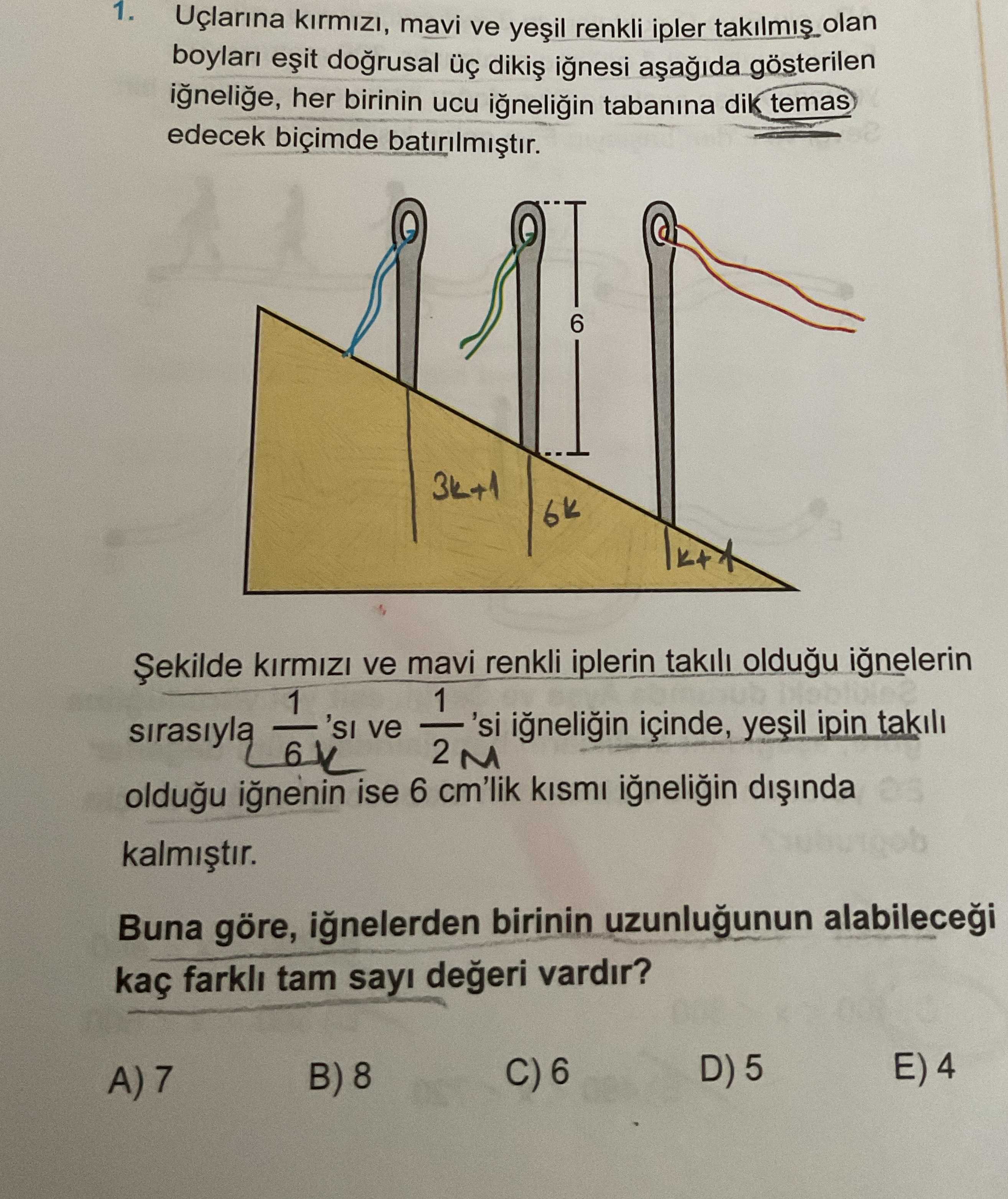 Uçlarına kırmızı, mavi ve yeşil renkli ipler takılmış olan boyları eşit doğrusal üç dikiş iğnesi