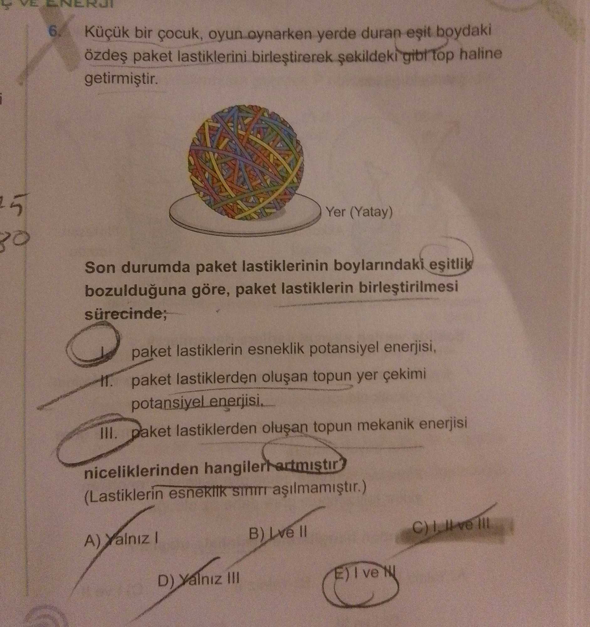 Küçük bir çocuk, oyun oynarken yerde duran eşit boydaki özdeş paket lastiklerini birleştirerek